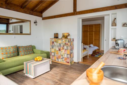 a living room with a green couch and a table at Poseydon Beach Bungalow in Mlini