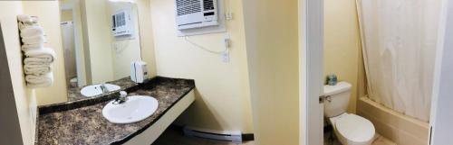 a small bathroom with two sinks and a toilet at Kings Motor Inn in Kamloops