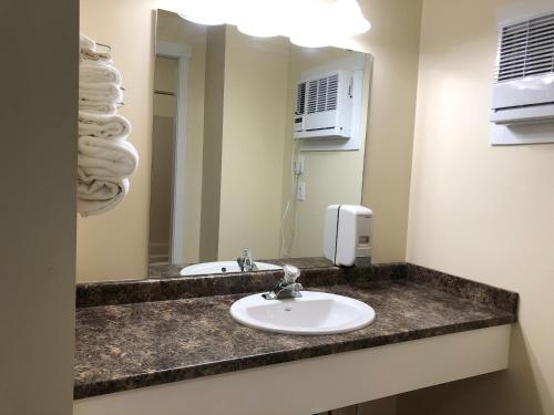 a bathroom with a sink and a mirror at Kings Motor Inn in Kamloops