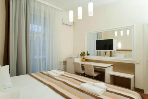a white bedroom with a desk and a bed at 7 Sky on Yevhena Konovaltsia in Kyiv