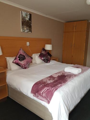 a bedroom with a large white bed with pillows at Noma-Nini Lodge in White River