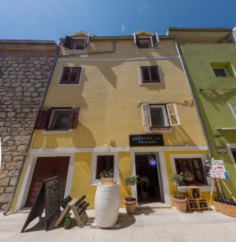 a yellow building with a sign in front of it at Mediterranean terrace apartment with Bikes & SUP in Skradin