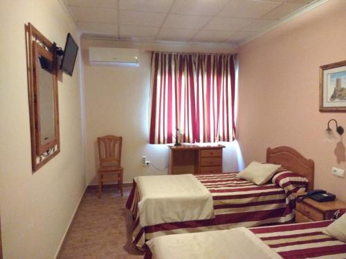 pokój hotelowy z dwoma łóżkami i oknem w obiekcie Hotel Mesón el Castillo w mieście Bañeres de Mariola
