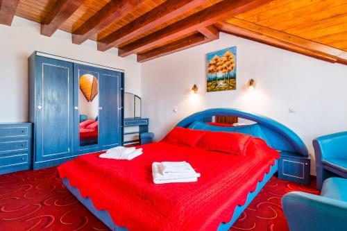 a bedroom with a red bed and blue chairs at Casa Luca in Vama Veche