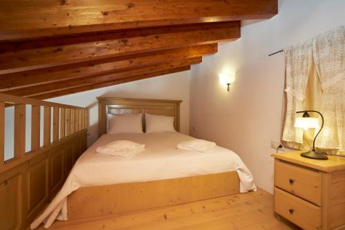 a bedroom with a bed in a room with wooden ceilings at Kaminos Boutique Hotel in Symi