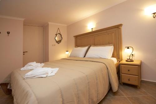 a bedroom with a large bed with two white towels on it at Kaminos Boutique Hotel in Symi