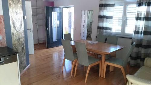 a dining room with a wooden table and chairs at FeWo - bei Tati 95qm in Singen