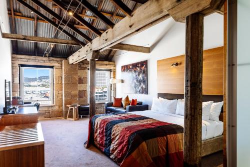 een slaapkamer met een bed en een bureau in een kamer bij The Henry Jones Art Hotel in Hobart