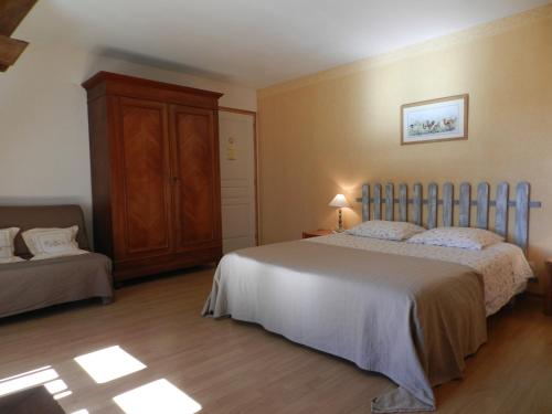 a bedroom with a bed and a dresser in it at La Ferme Montplaisir in Montesquieu-Volvestre