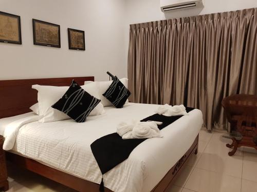a bedroom with two beds with towels on them at Heeren Straits Hotel in Melaka