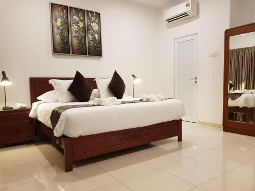 a bedroom with a large bed with white sheets at Heeren Straits Hotel in Melaka
