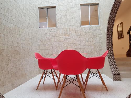 two red chairs sitting next to a brick wall at Heeren Straits Hotel in Melaka