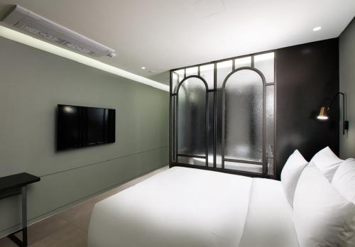 a bedroom with a white bed with a window at Park Marine Hotel in Incheon