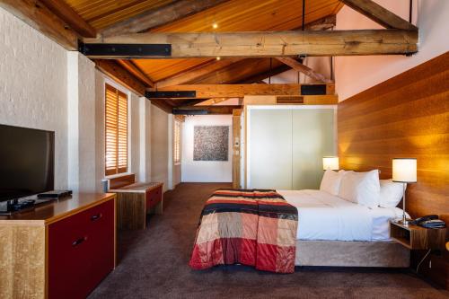 a hotel room with a bed and a television at The Henry Jones Art Hotel in Hobart