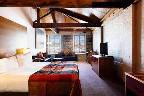 a hotel room with a bed and a tv at The Henry Jones Art Hotel in Hobart
