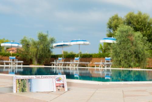 a book sitting on the ground next to a swimming pool at Antico Podere San Francesco in Vada