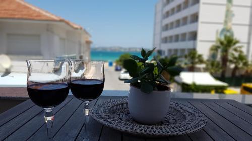 dos copas de vino en una mesa con una planta en İleri Hotel & Apartments, en Cesme