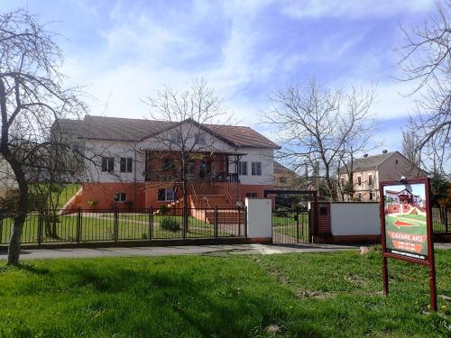 een huis met een hek en een bord ervoor bij Vila Zuela in Buziaş