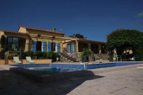una casa con piscina frente a ella en Villa Azurella, en Brignoles