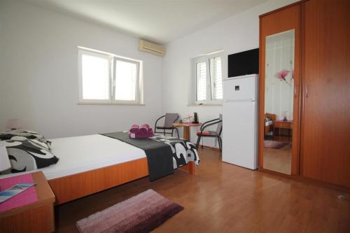 1 dormitorio con 1 cama, nevera y mesa en Private Accommodation Carevic, en Dubrovnik