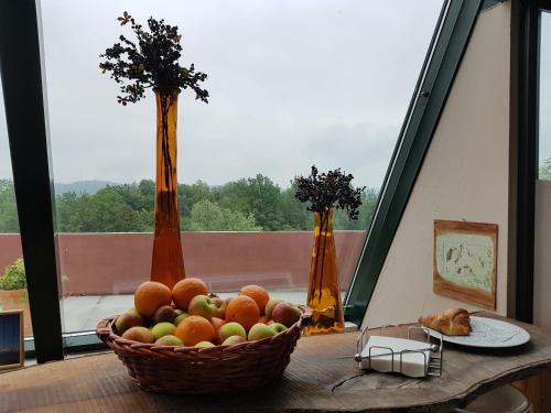 a basket of fruit sitting on a table in front of a window at Hotel Medno in Ljubljana