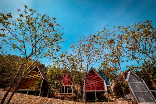 a group of houses with red roofs and trees at Radika Paradise Villa & Cottage in Tepus