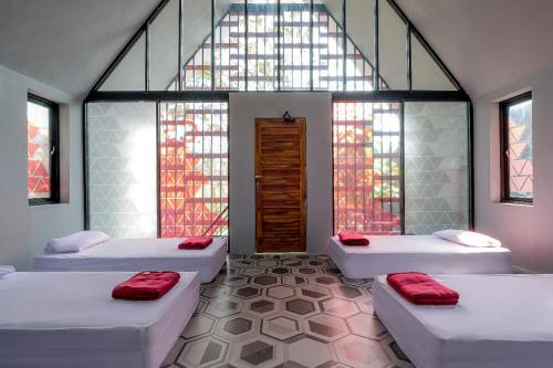 a room with three beds and a large window at Radika Paradise Villa & Cottage in Tepus