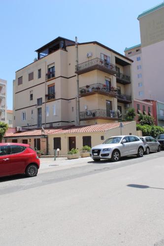 two cars parked on a street in front of a building at RelaisApartments PORTO in Alghero