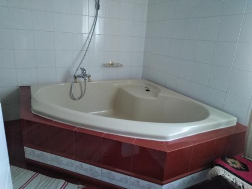 a white bath tub in a bathroom with red tiles at Casa di Luca in Agrigento