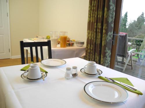 a table with plates and napkins on top of it at Oakside Lodge Guest House in Canterbury