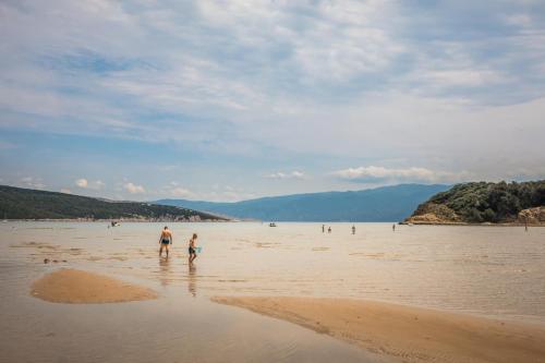 a man and a child walking on the beach at San Marino Resort in Lopar