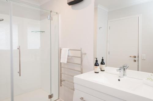a white bathroom with a sink and a shower at Luxury Rata Apartment - A in Twizel