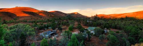 a house on a hill with mountains in the background at Skytrek Willow Springs Station in Flinders Ranges
