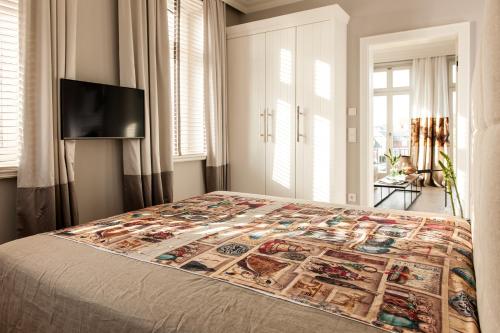 a bedroom with a bed with a quilt on it at Hotel Sylter Zollhaus in Westerland (Sylt)