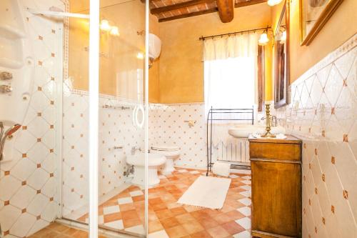 een badkamer met een douche, een toilet en een wastafel bij Holiday apartments La Bozza and Il Bozzino in Cortona