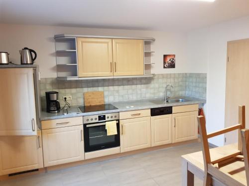 a kitchen with wooden cabinets and a stove top oven at Störmthal Ferienwohnung 1 Sonnenweg in Störmthal