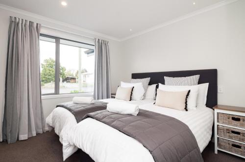 Un dormitorio con una cama grande y una ventana en Luxury Rata Apartment - B en Twizel