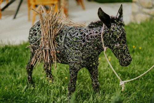 a toy horse is tied up in the grass at Hotel & Wine Cellar ARGE in Tʼelavi