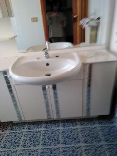 a white sink in a bathroom with a mirror at Casa di Luca in Agrigento