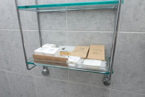 two boxes on a glass shelf in a bathroom at Zenit Hotel in Giulianova