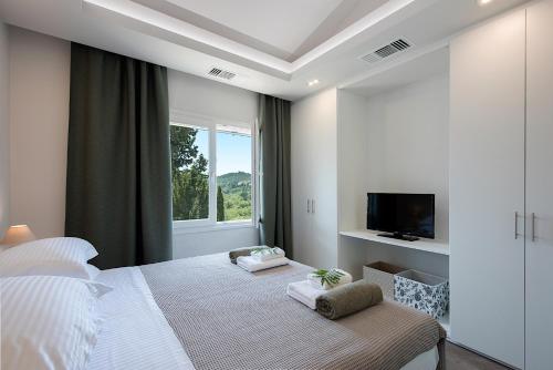 a white bedroom with a bed and a window at Gem Villa in Viros Corfu in Virós