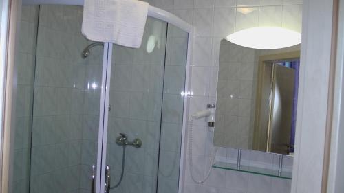 y baño con ducha y espejo. en Assos Hotel, en Asbach-Bäumenheim