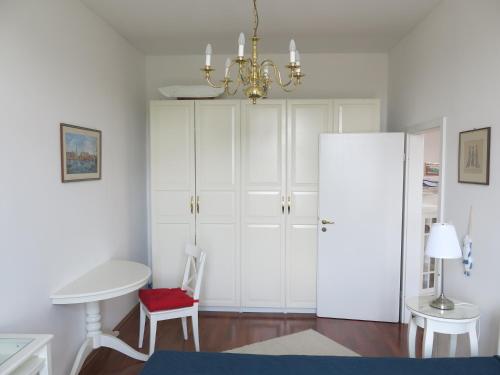 a bedroom with white cabinets and a chandelier at Horvath Villa Apartman Aliz in Balatonfüred