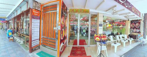 a store front of a store with tables and chairs at Walking Street Residence - Boutique Suites near the Beach & Walking Street in Pattaya South
