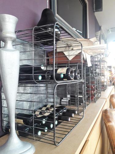 a wire dish drying rack with wine bottles at Châtellerie De Schoebeque in Cassel