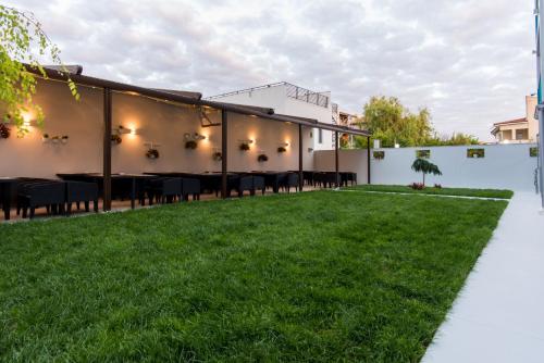 an outdoor patio with a table and grass at Turquoise Boutique Mamaia Nord in Mamaia Sat/Năvodari