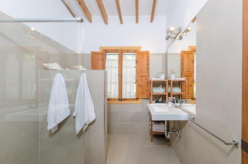 a bathroom with a sink and a glass shower at Cas Garriguer in Andratx