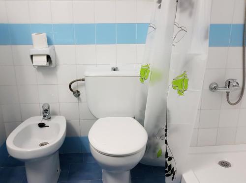 a bathroom with a white toilet and a sink at Sunny Beach in Benalmádena