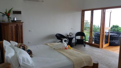a bedroom with a bed and a sliding glass door at Korovesi Sunshine Villas in Savusavu