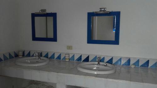 two sinks in a bathroom with two mirrors at Villa Vista Mare a Filicudi in Filicudi